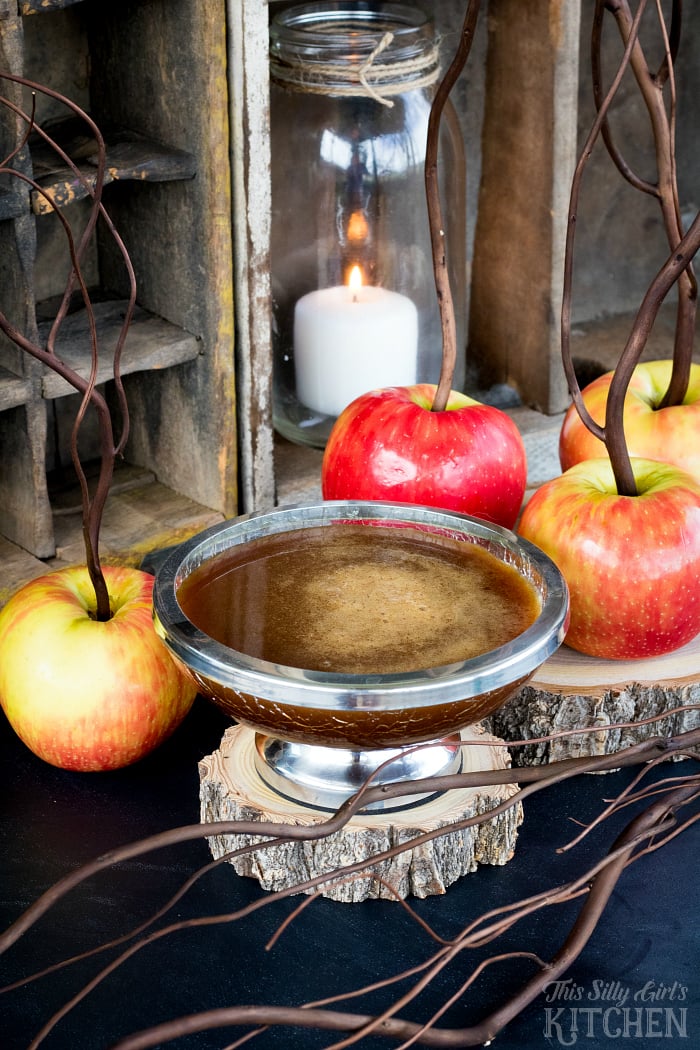 Cinnamon Buttermilk Caramel Sauce Recipe in silver bowl surrounded by apples. 