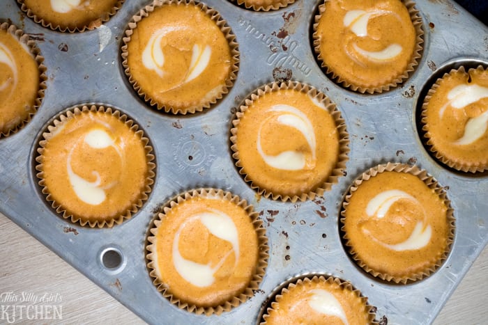 Overhead photo of finished Pumpkin Cheesecake Cupcakes in muffin tin.
