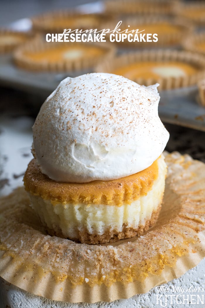 Pumpkin Cheesecake Cupcakes with paper liner pulled down and topped with whipped cream.