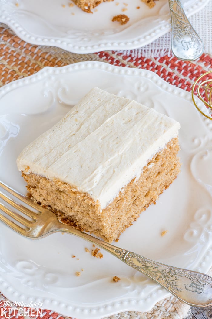Overhead of frosted Spiced Apple Cider Sheet Cake on white plate showing frosting.