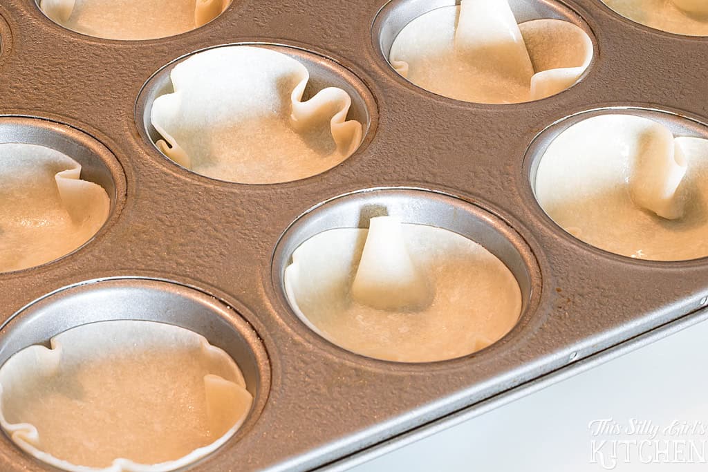 Tortilla rounds pressed into a muffin tin forming little cups.