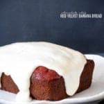 A whole loaf of Chocolate Chip Red Velvet Banana Bread topped with cream cheese icing.
