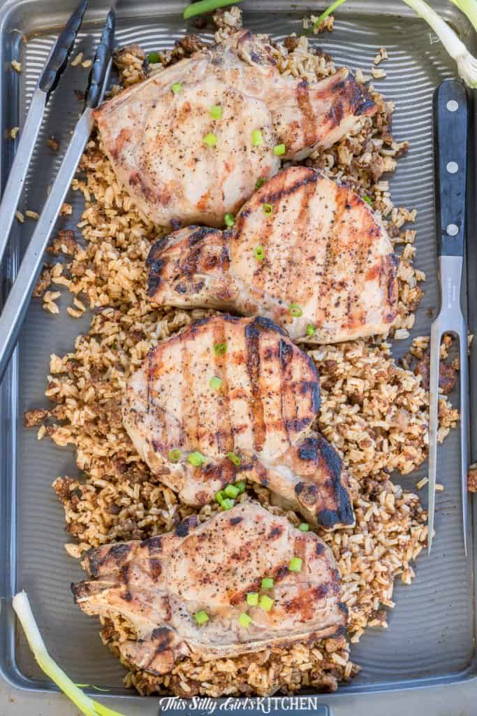 Juicy brown sugar brined grilled pork chops served over seasoned rice with scallions.