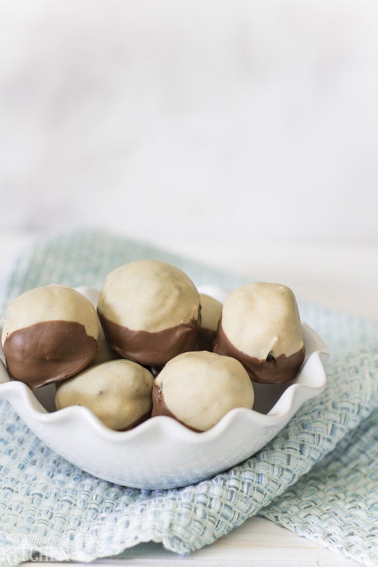 A bowl of peanut butter Oreo truffles dipped in a creamy coating with a chocolate bottom.