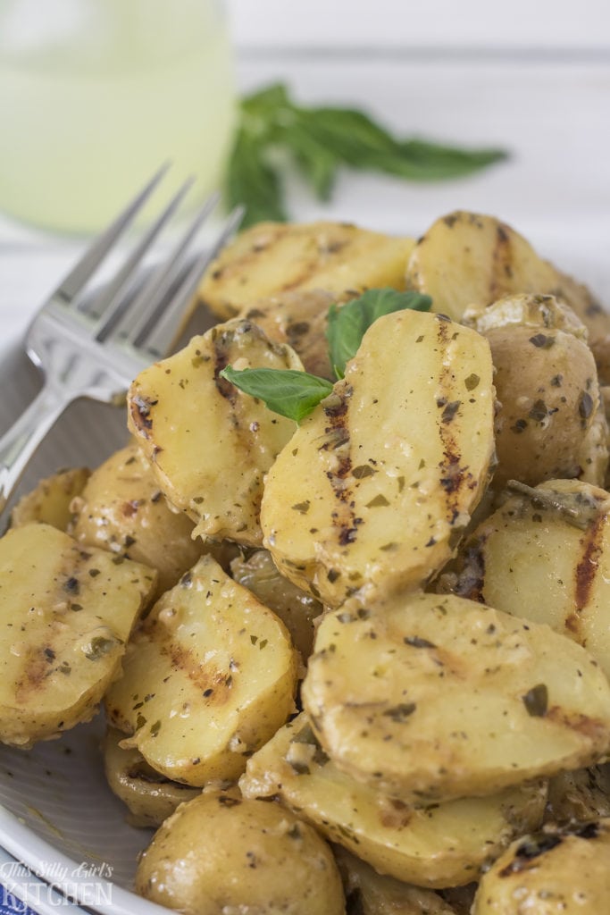 Warm Grilled Potato Salad, tender baby yellow basted in a tangy pesto marinade and grilled! #Recipe from ThisSillyGirlsKitchen.com #grilled #grilledpotatosalad #potatosalad #bobbyflay #warmpotatosalad