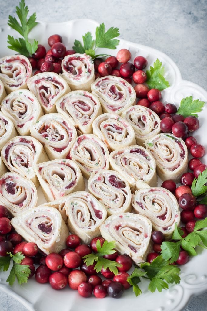 Cranberry Turkey Pinwheels on serving tray with cranberries and parsley 