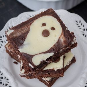 Stacked Ghost Cheesecake Brownies on white plate square image.