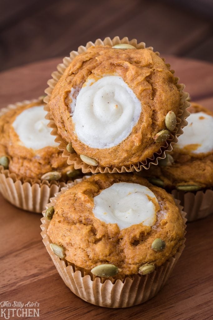 Stacked Pumpkin Cream Cheese Muffins showing filling in center.