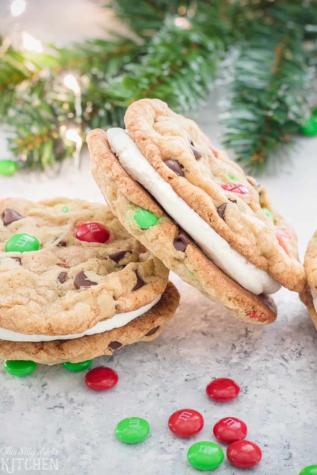 Christmas Cookie Sandwiches, the fluffiest buttercream frosting sandwiched between two soft and chewy chocolate chip cookies loaded with holiday M&M's! #Recipe from ThisSillyGirlsKitchen.com #ChristmasCookies #SandwichCookies #CookiesForSanta #Christmas