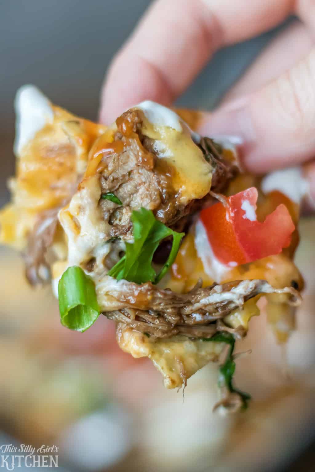 #BBQ Beef #Nachos, layered nachos piled high with tender beef, cheese sauce, and all the fixins! #Recipe from ThisSillyGirlsKitchen.com #bbqbeef #appetizer