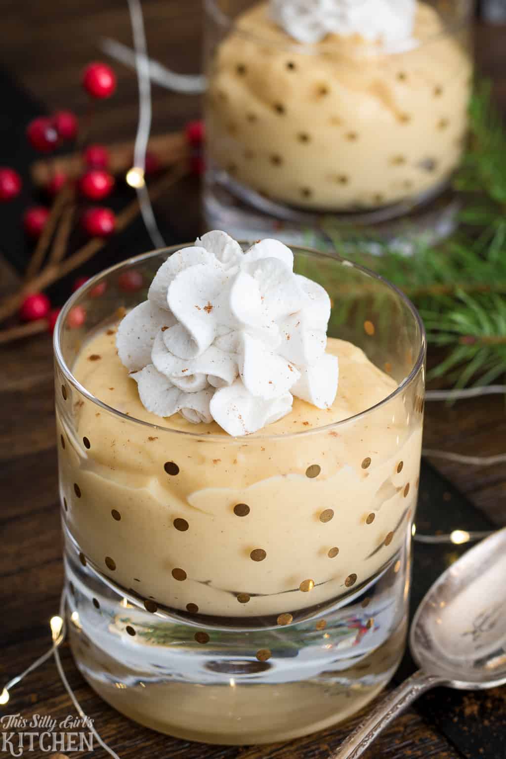 Eggnog Pudding in two glasses topped with whipped cream
