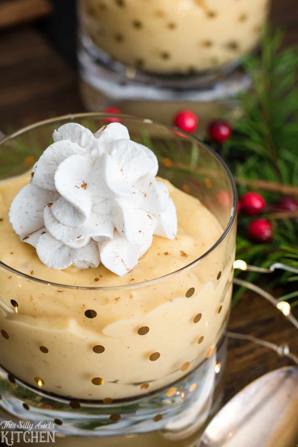 Close up of whipped cream topped Eggnog Pudding in clear glass
