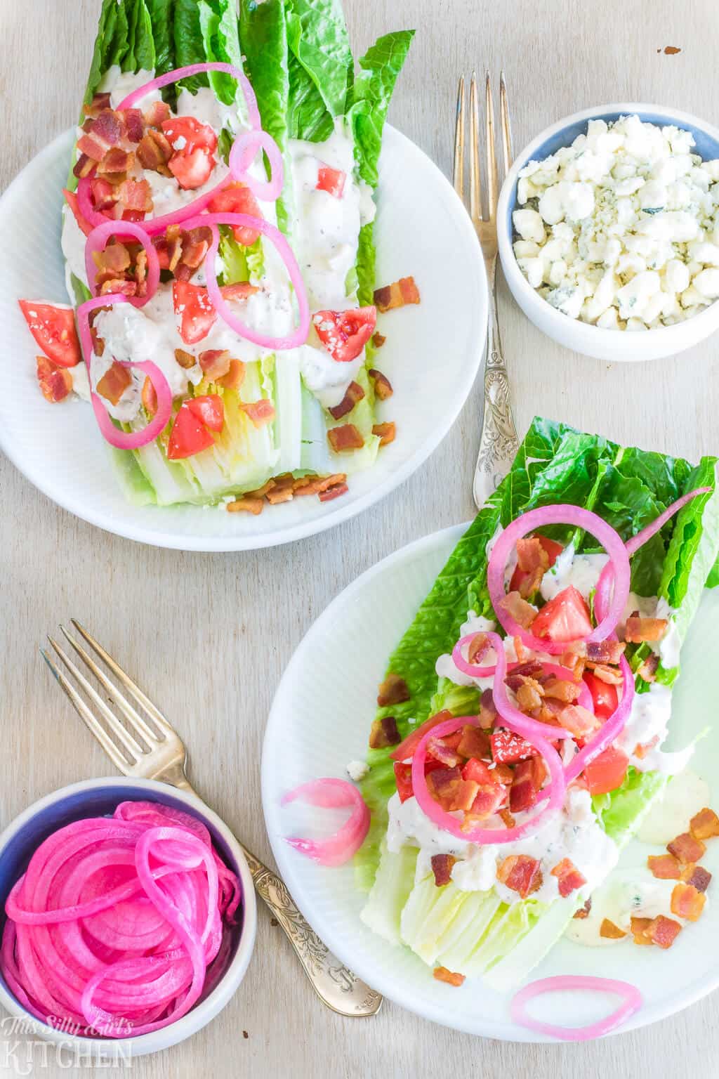 Two Salad Wedges on white plates topped with toppings overhead photo