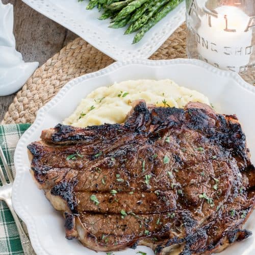 Best Ribeye Marinade Recipe finished on the grill, sliced and resting on a wooden cutting board.