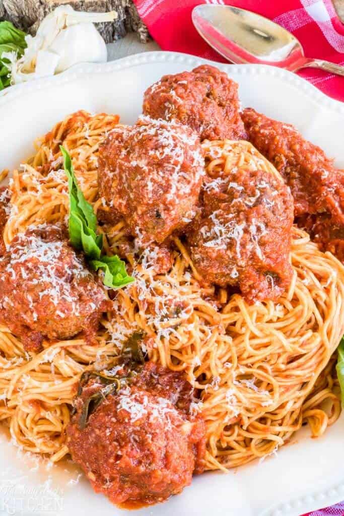 Very close up of Spaghetti and Meatballs Recipe on white plate with basil
