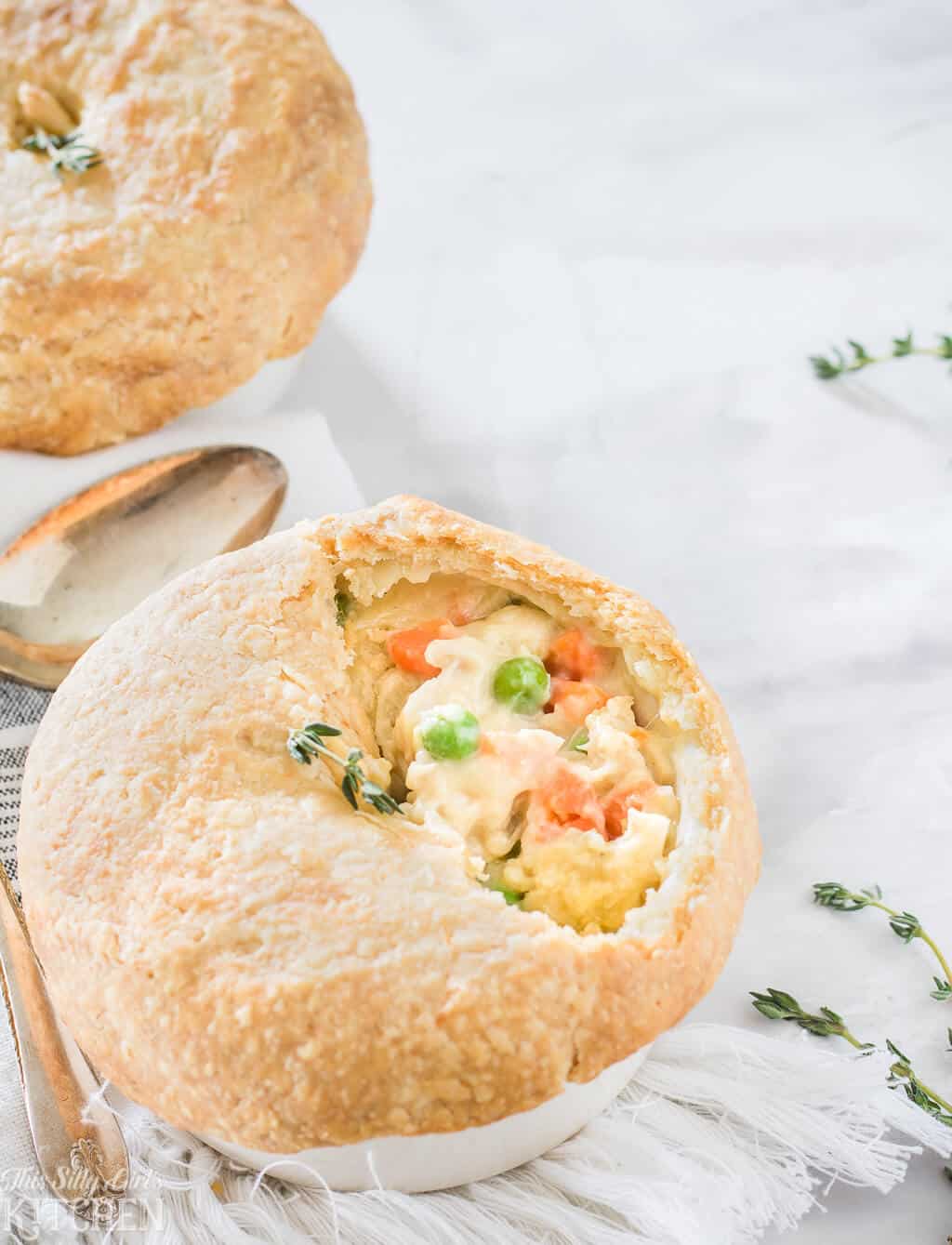 Close up of one pot pie topped with fresh herbs showing inside
