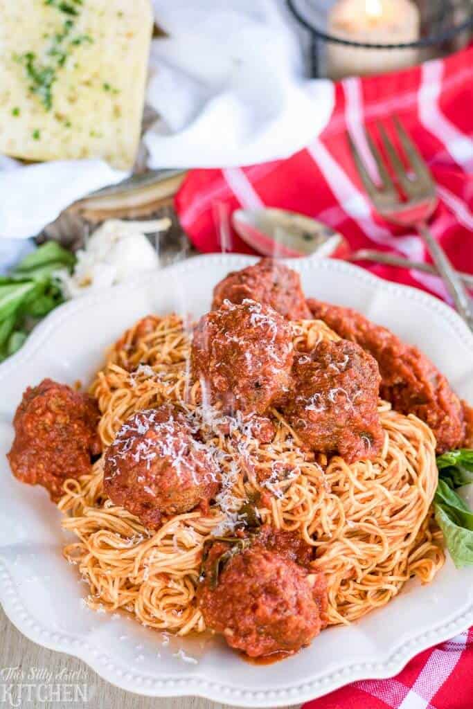 Close up of Sauce and Meatballs over spaghetti on white plate