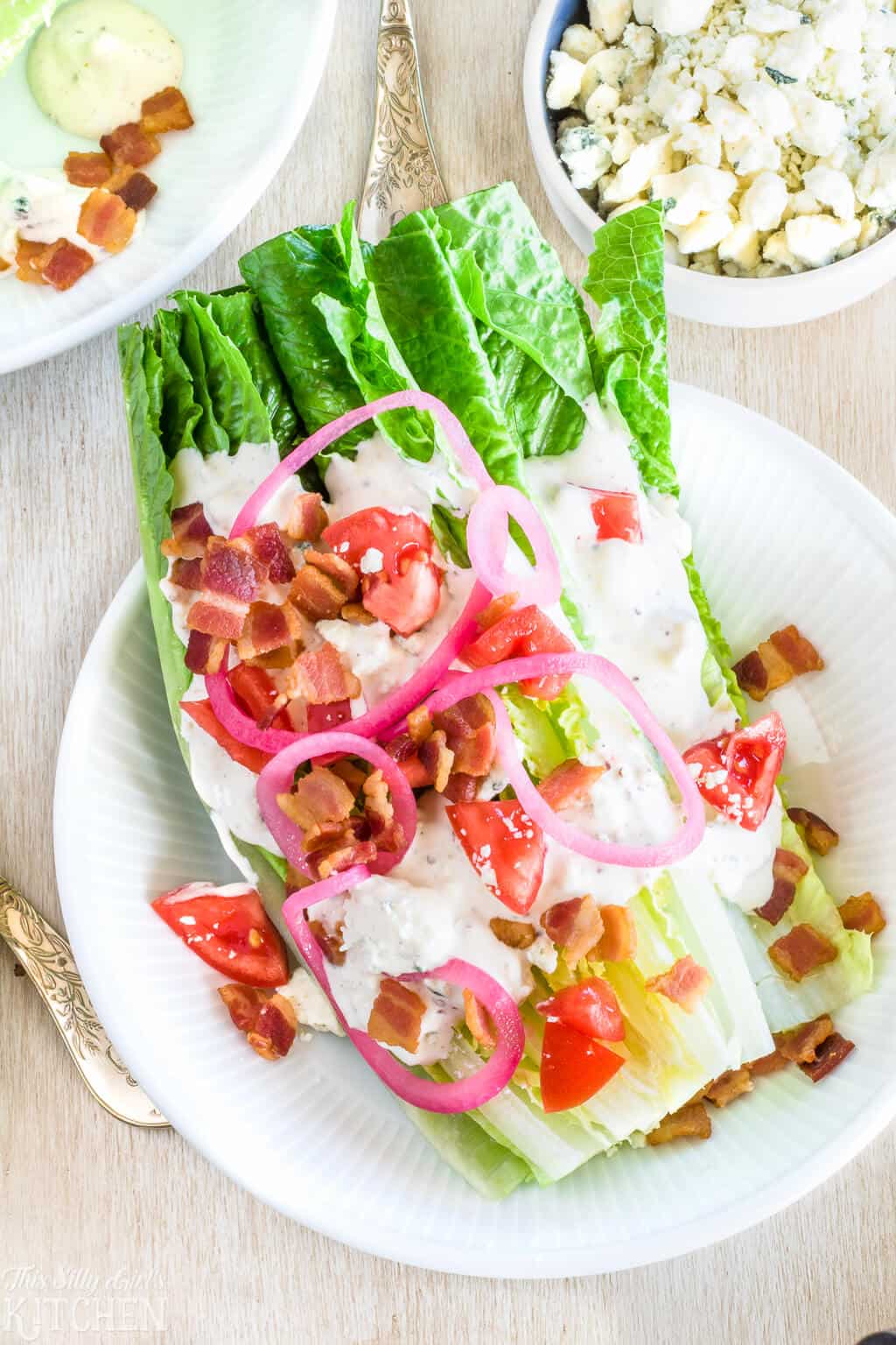 Romaine Wedge Salad Recipe on white plate topped with dressing and toppings