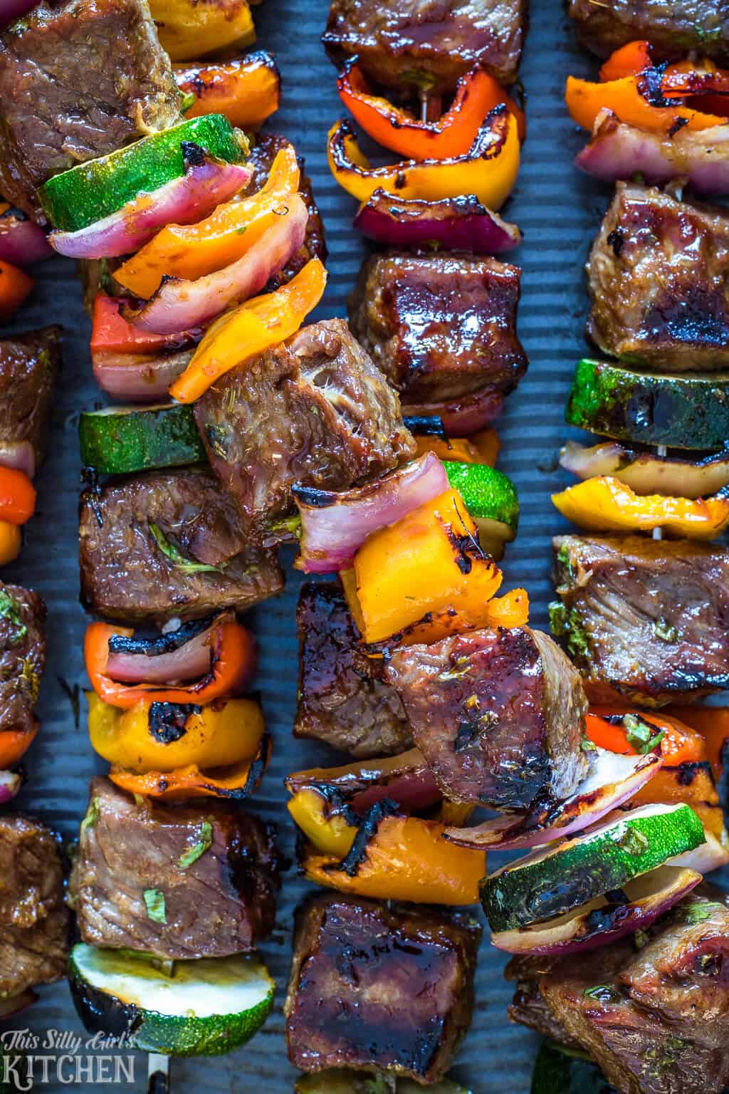 Close up of finished Carne Asada Steak Kabobs on skewers on baking pan