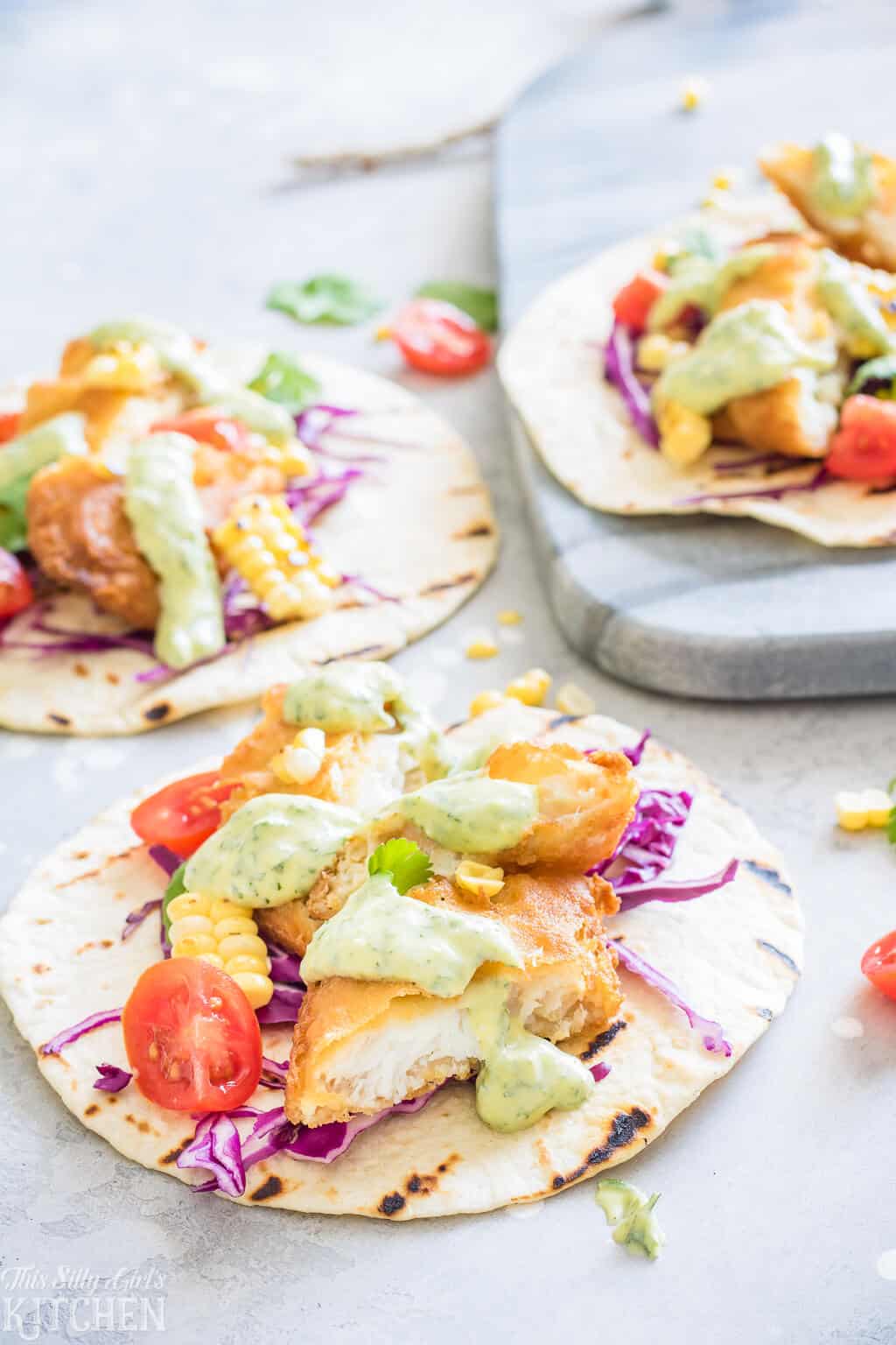 Easy Fish Tacos with Creamy Chimichurri Sauce, an easy weeknight meal you will make again and again! #Recipe from ThisSillyGirlsKitchen.com #fishtaco #taco #chimichurri