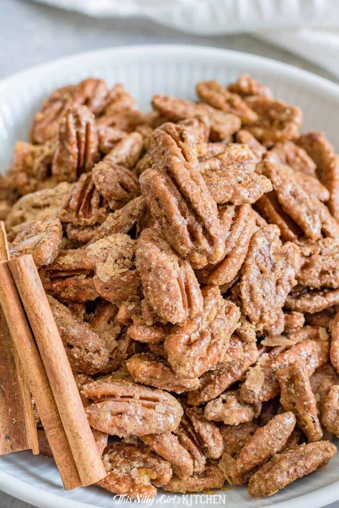 Close up of Pecans in white bowl with cinnamon sticks