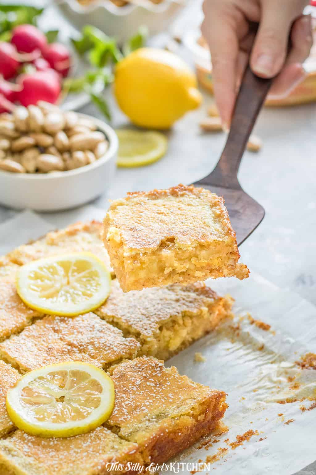 Gooey lemon bars are bursting with bright citrusy flavors, perfect for summer. #Recipe from ThisSillyGirlsKitchen.com #lemonbars #oatmealbars #almond #lemon