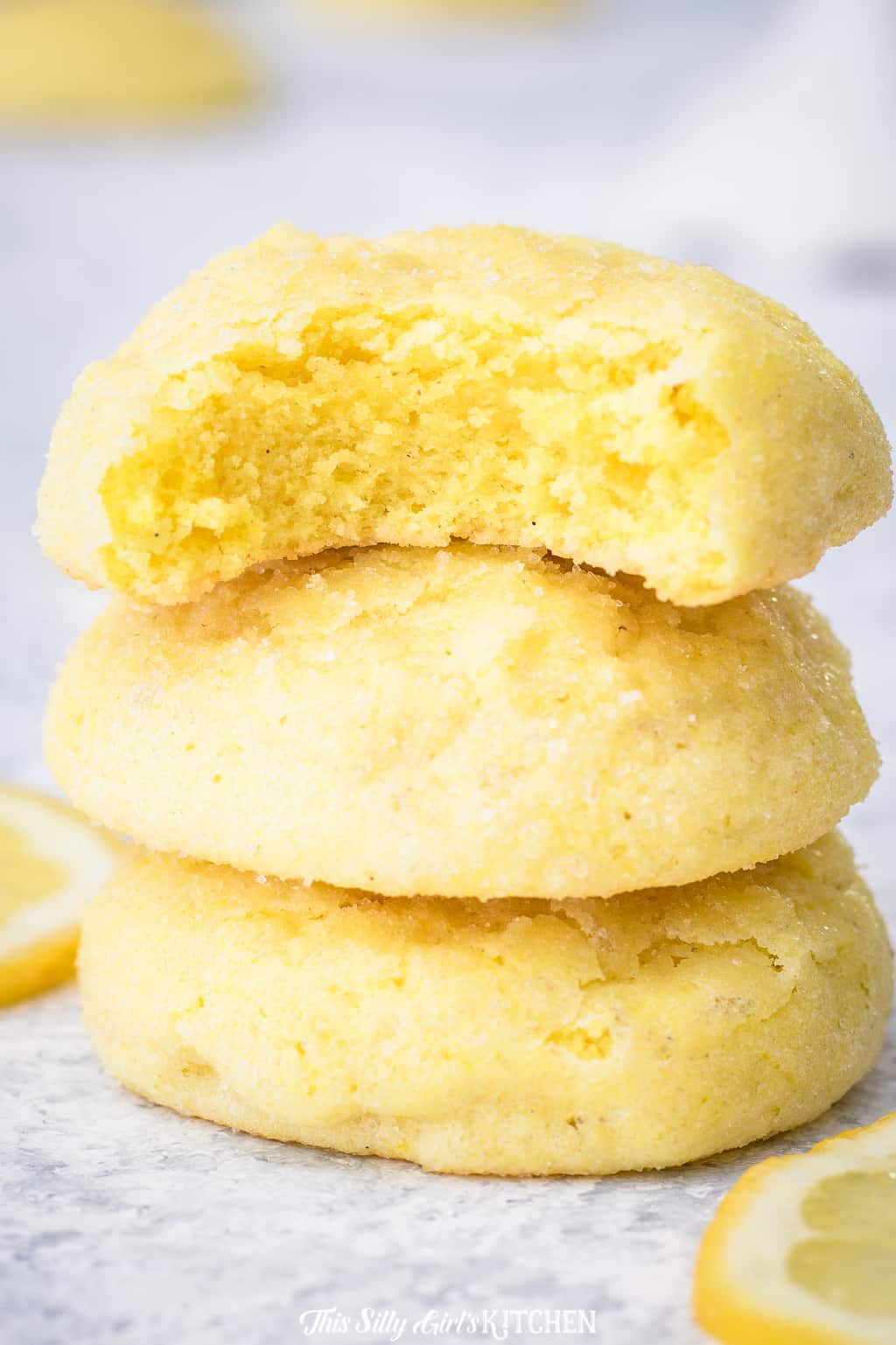 Three Meltaway Lemon Cookie stacked with a bite taken out of one