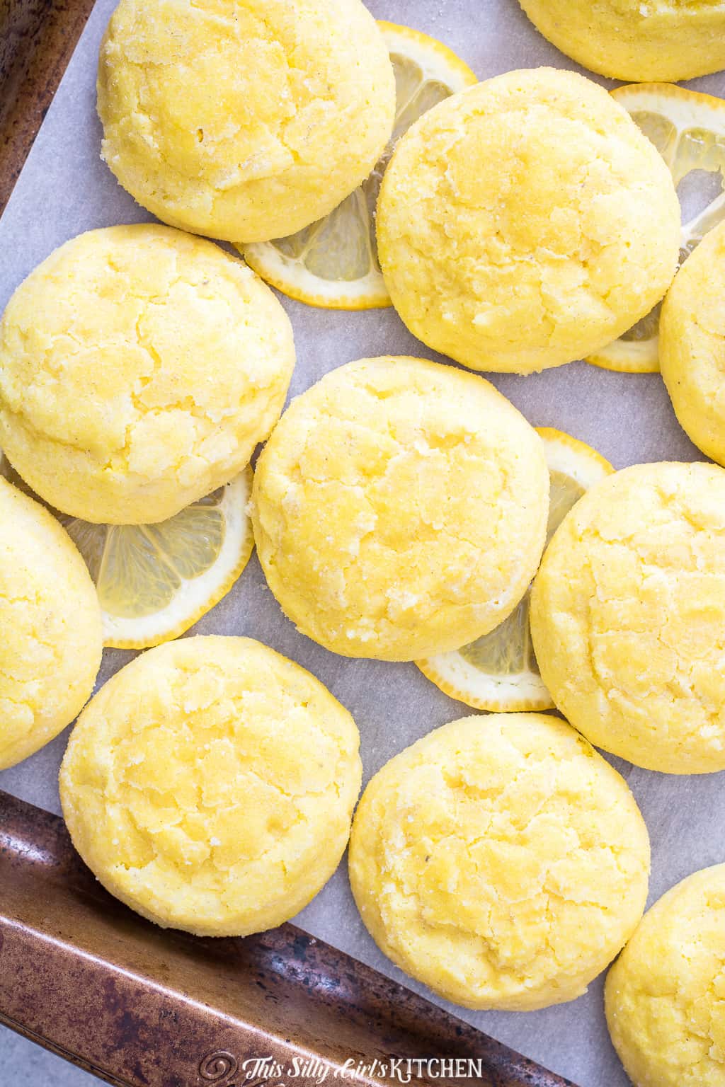Meltaway Lemon Cookies on sheet pan with lemon slices
