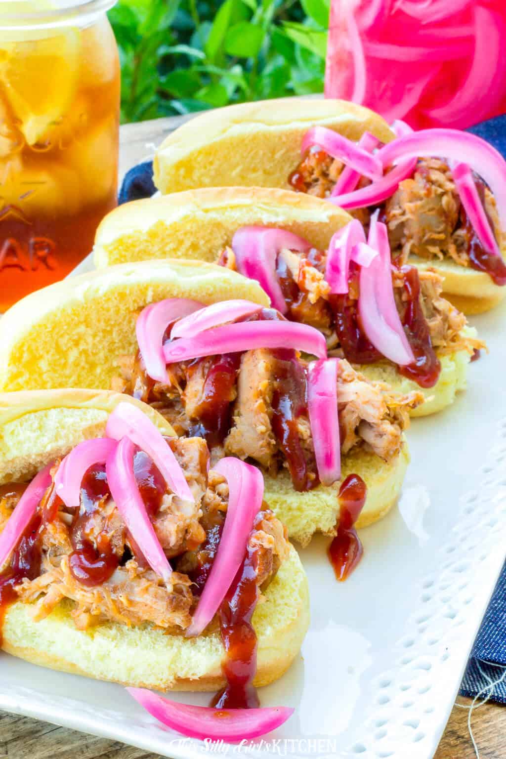 Close up of pulled pork on slider buns with onions