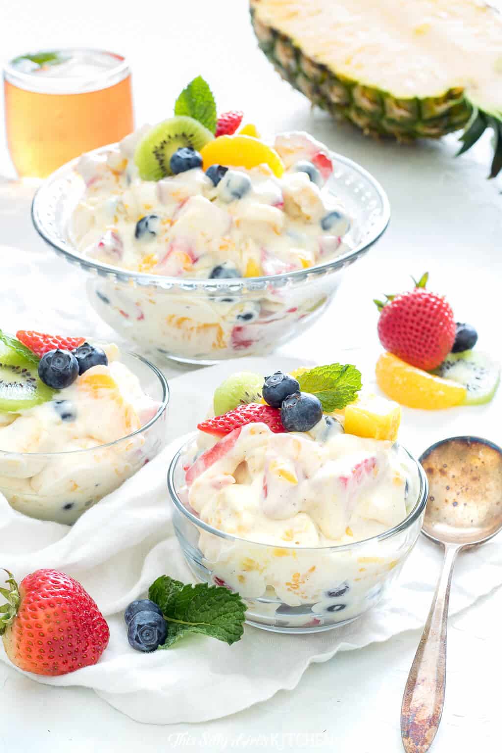 Cheesecake Salad in large bowl then some in smaller bowls topped with fruit and mint