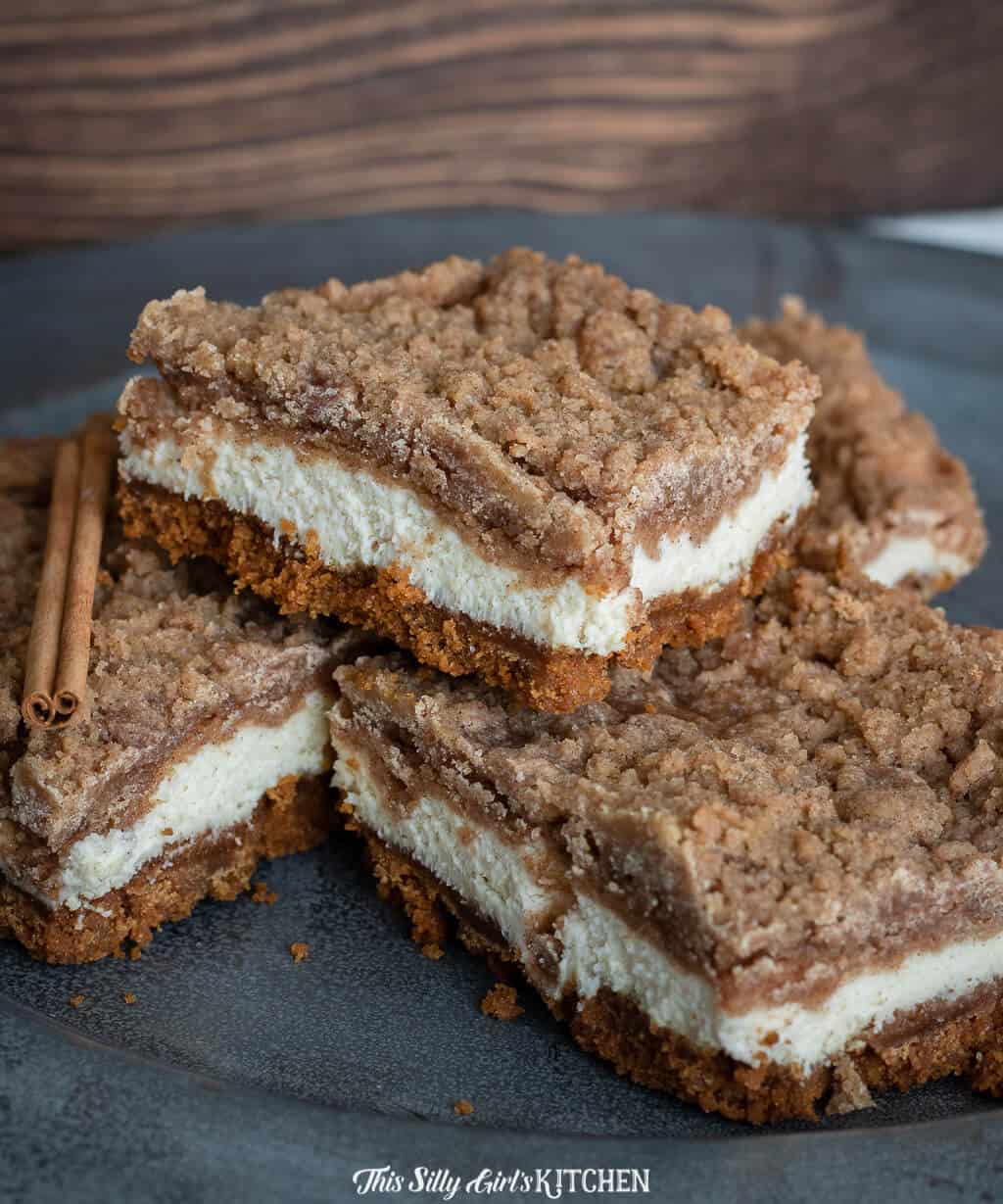 Snickerdoodle Bars stacked on top of one another on black plate.