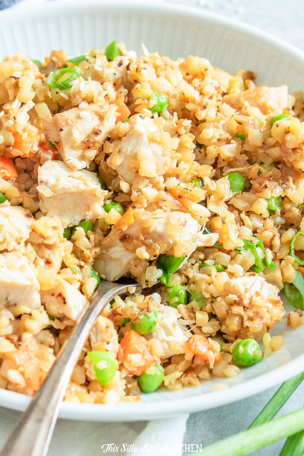 Loaded with veggies and chicken this cauliflower chicken fried rice is a healthier alternative to classic fried rice. #recipe from thissillygirlskitchen.com #friedrice #chicken #chickenfriedrice #cauliflowerrice
