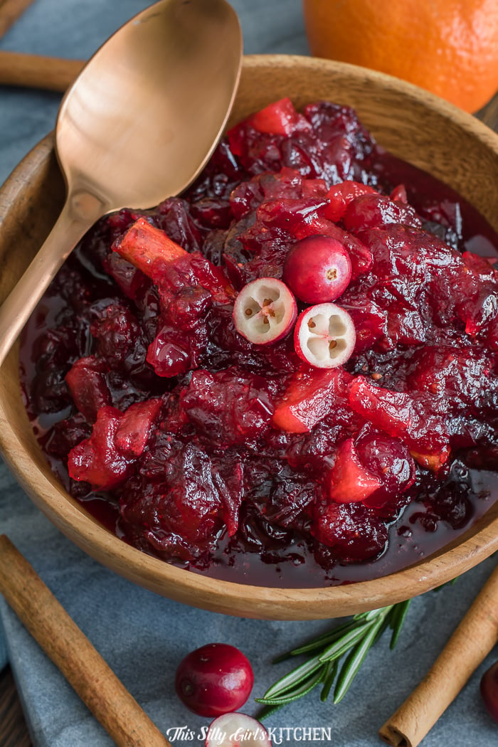 Close up of Cranberry Sauce in bowl with golden spoon and cinnamon sticks
