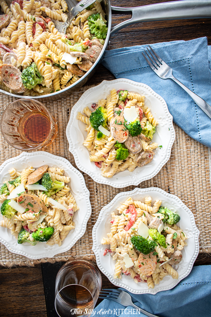 Ready in under 25 minutes, creamy, loaded with broccoli, chicken sausage, and roasted red bell peppers. This chicken broccoli pasta is a knock-out dish! #recipe from thissillygirlskitchen.com #chicken #alfrescochickensausage #broccoli #pasta #onepot #cheese #creamypasta