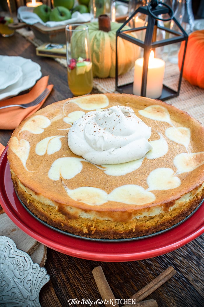 Close up of Pumpkin Cheesecake on pan topped with whipped topping