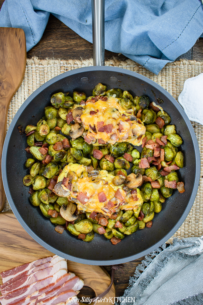 Chicken overhead in pan with melted cheese and Brussel sprouts 