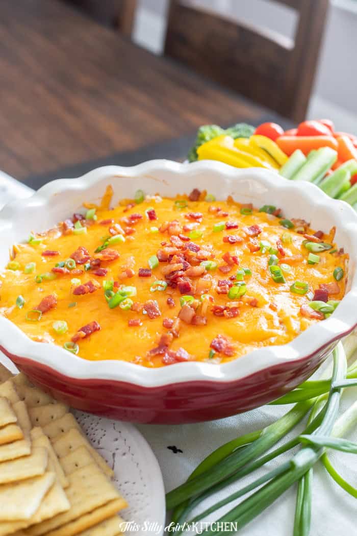 Close-up of creamy crack chicken dip topped with bacon and green onion.
