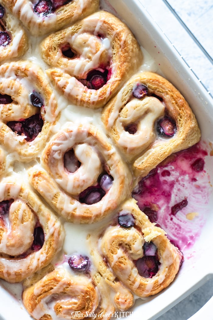 Lemon Berry Sweet Rolls in baking pan with one roll missing 