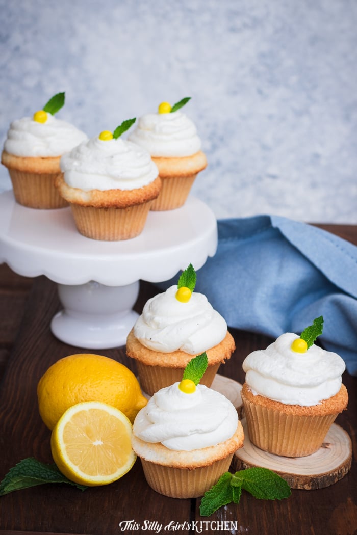 Cupcakes on cake stand and on wooden surface with mint and lemons