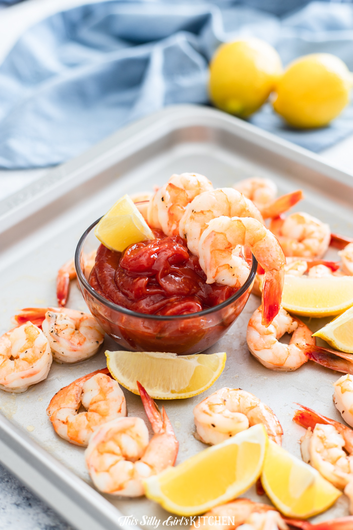 Roasted Shrimp Cocktail being served with sauce and shrimp over bowl of sauce