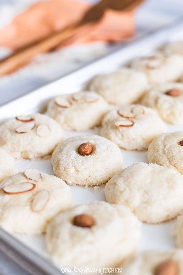Close up of Meltaway Almond Cookies on baking sheet topped with almonds