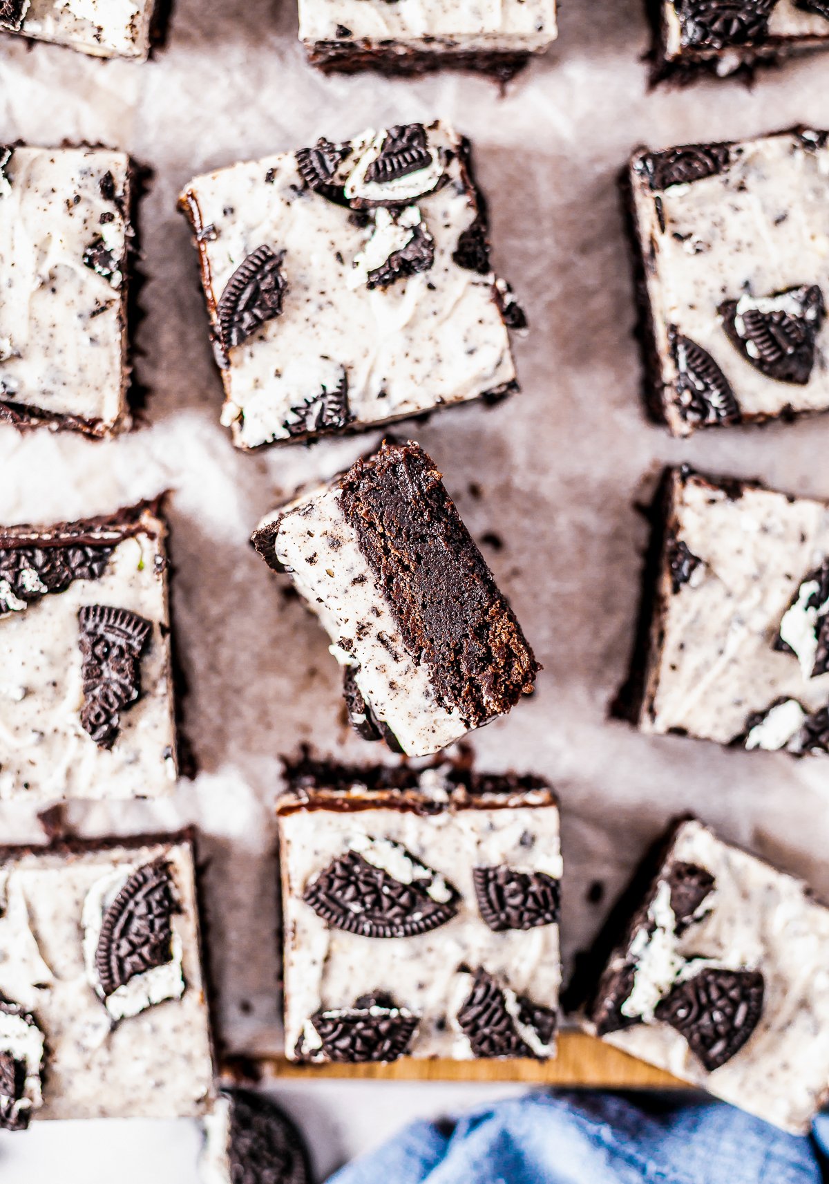 Overhead photo of cut Oreo Fudge Brownies with one on its side showing layers.