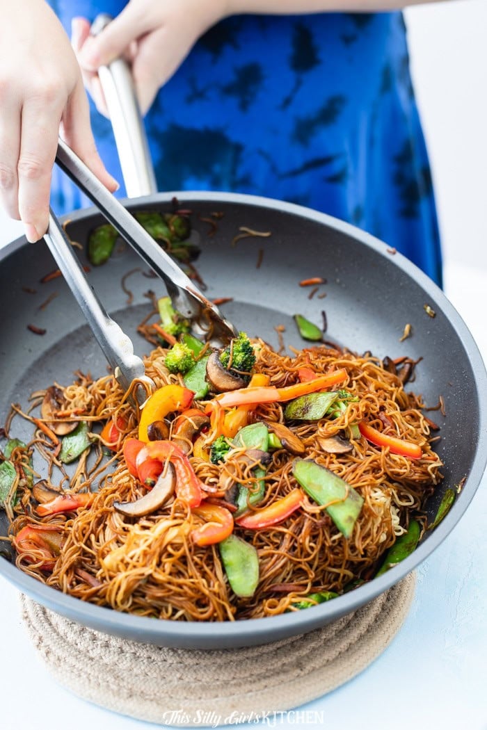 Vegetable Lo Mein being tossed together in a hot skillet.