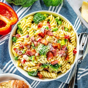 Broccoli Pasta Salad overhead in white bowl with ingredients surrounding bowl