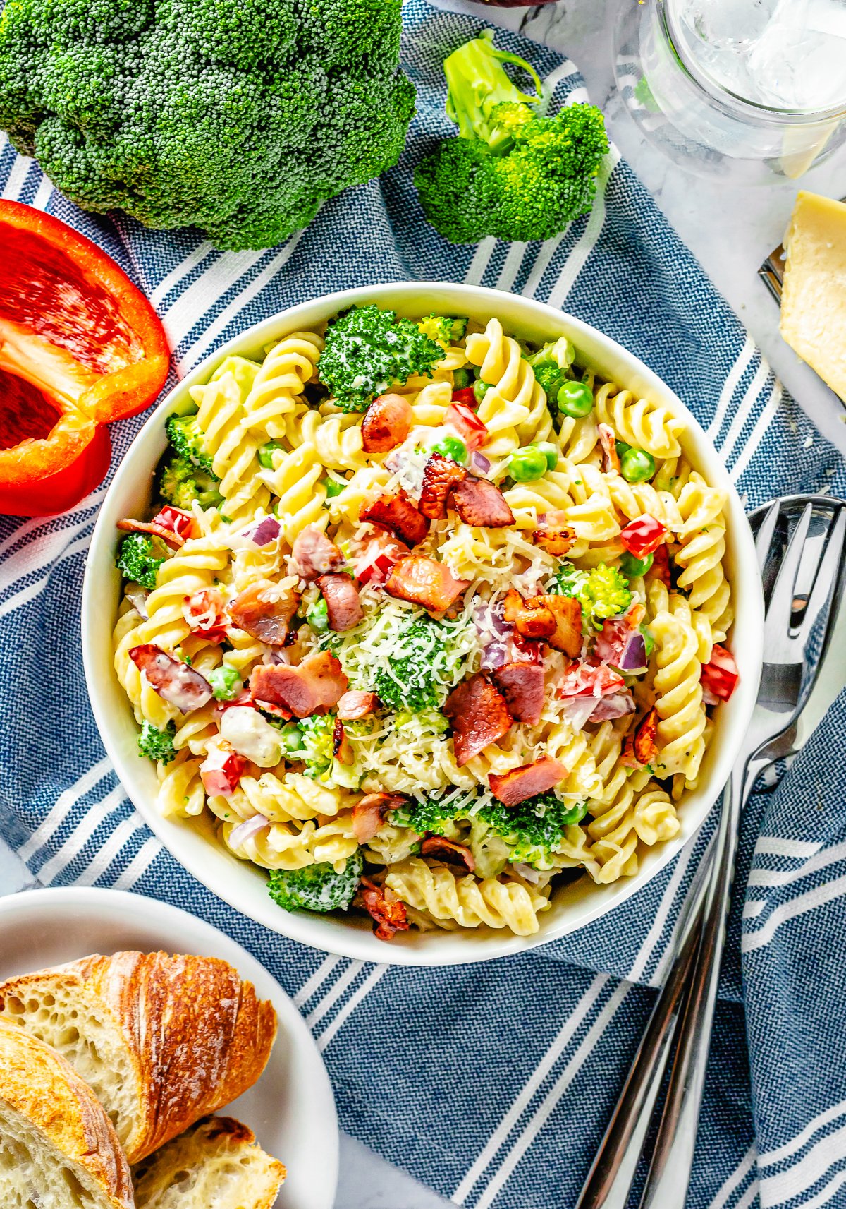 Broccoli Pasta Salad overhead in white bowl with ingredients surrounding bowl