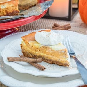 Pumpkin cheesecake on plate with cinnamon sticks square image