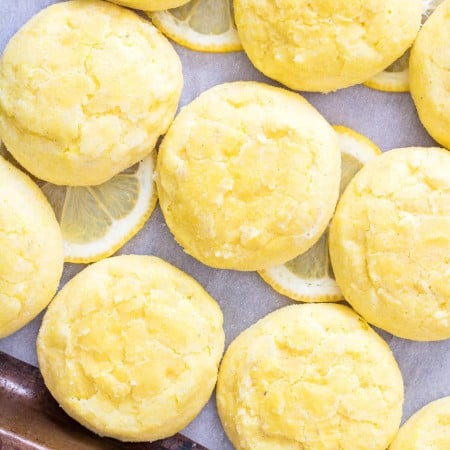 Close up overhead of lemon cookies on baking pan with lemon slices square image