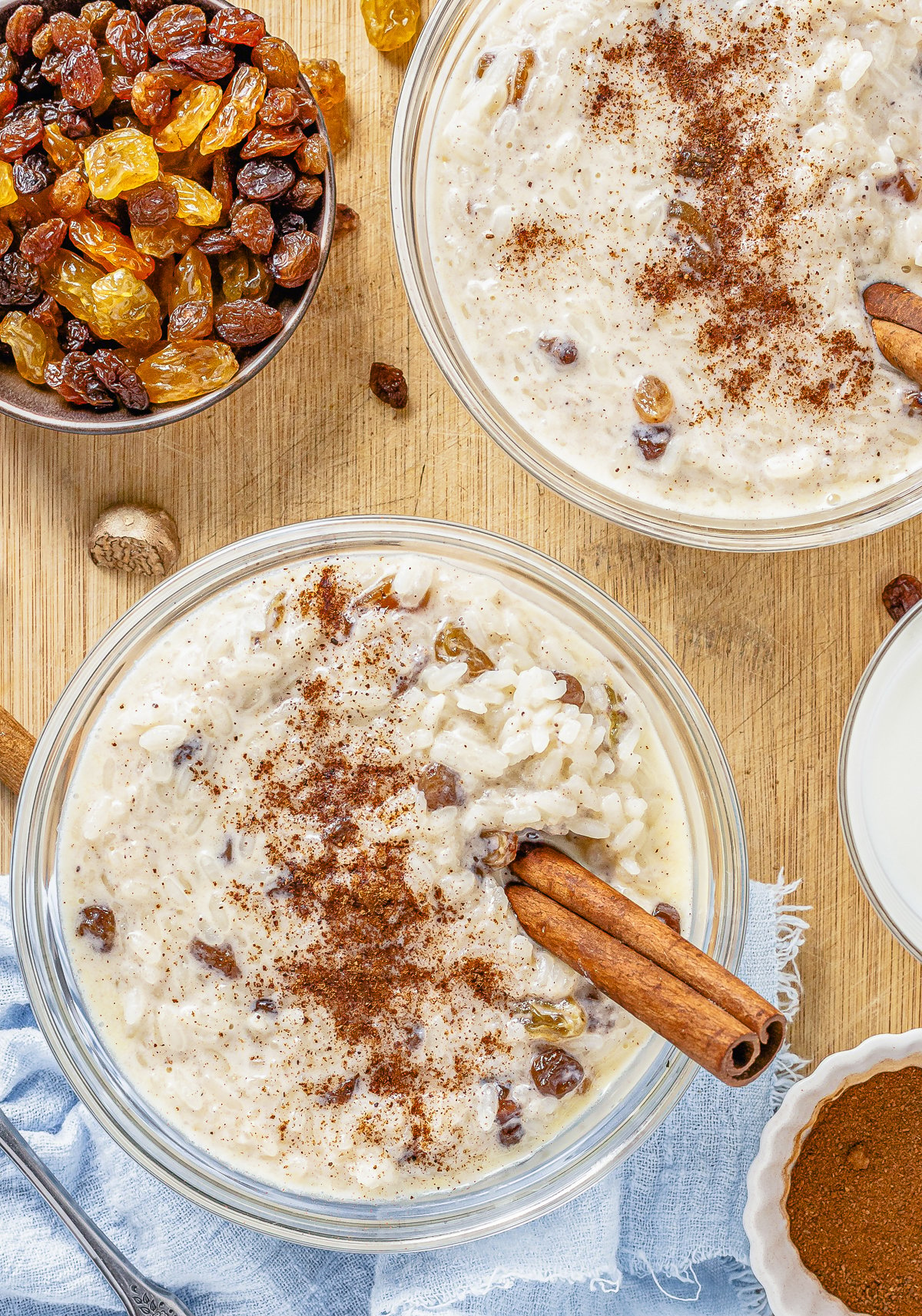 Two bowls of Rice Pudding with Cooked Rice with cinnamon and cinnamon sticks.