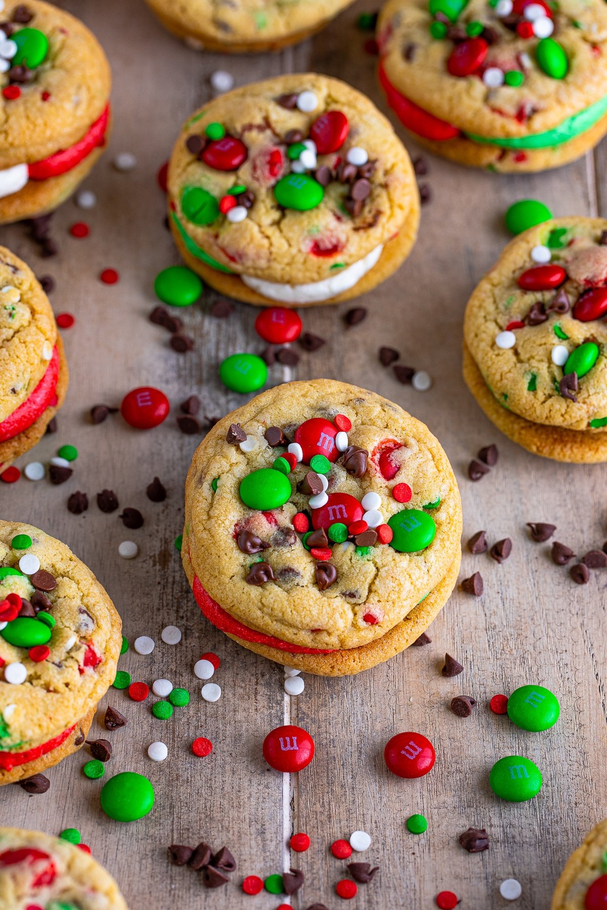Overhead photo of finished Christmas Sandwich Cookies with M&M's and sprinkles around them.