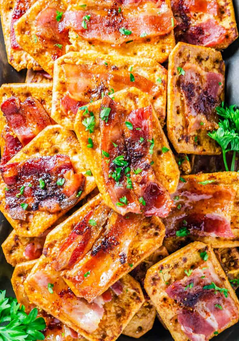 A platter of glazed Bacon Crackers topped with caramelized brown sugar bacon and fresh parsley.